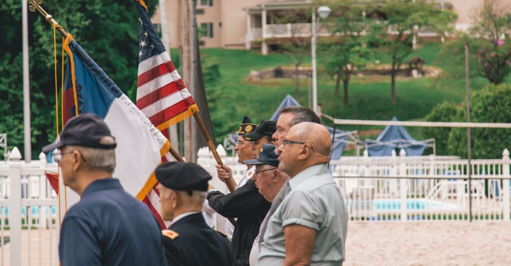 Group of veterans holding flags during an outdoor ceremony showing patriotism.