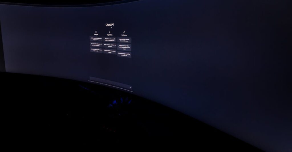 Curved monitor screen showing ChatGPT interface in low-light, focus on technology and AI.