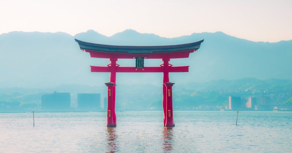 A captivating shot of the iconic Torii gate of Itsukushima Shrine, blending tradition with serene water and mountains.