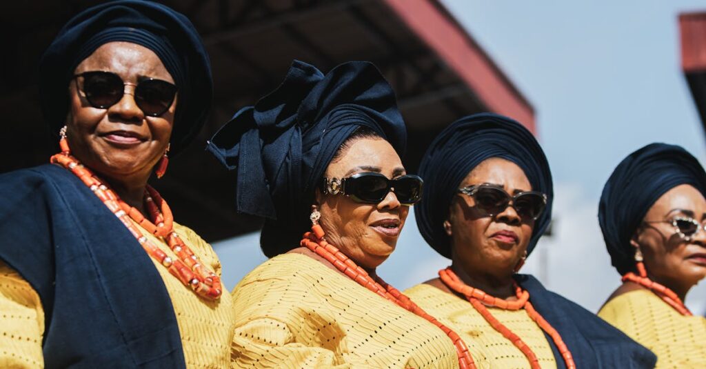 Women in traditional Yoruba attire, wearing vibrant gele and beads at a Nigerian cultural event.