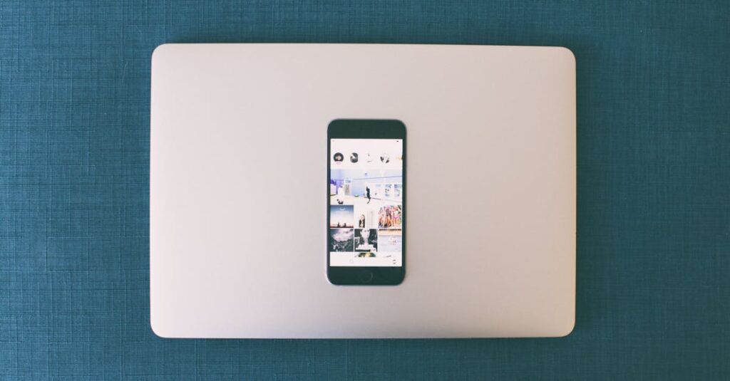 Flat lay of a smartphone on a laptop with social media photos on screen.