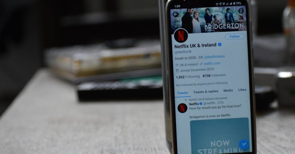 Smartphone showing Netflix's Twitter page on a wooden table.