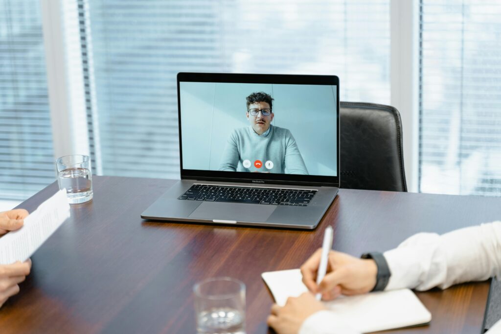A professional setting with a virtual meeting on a laptop in an office.
