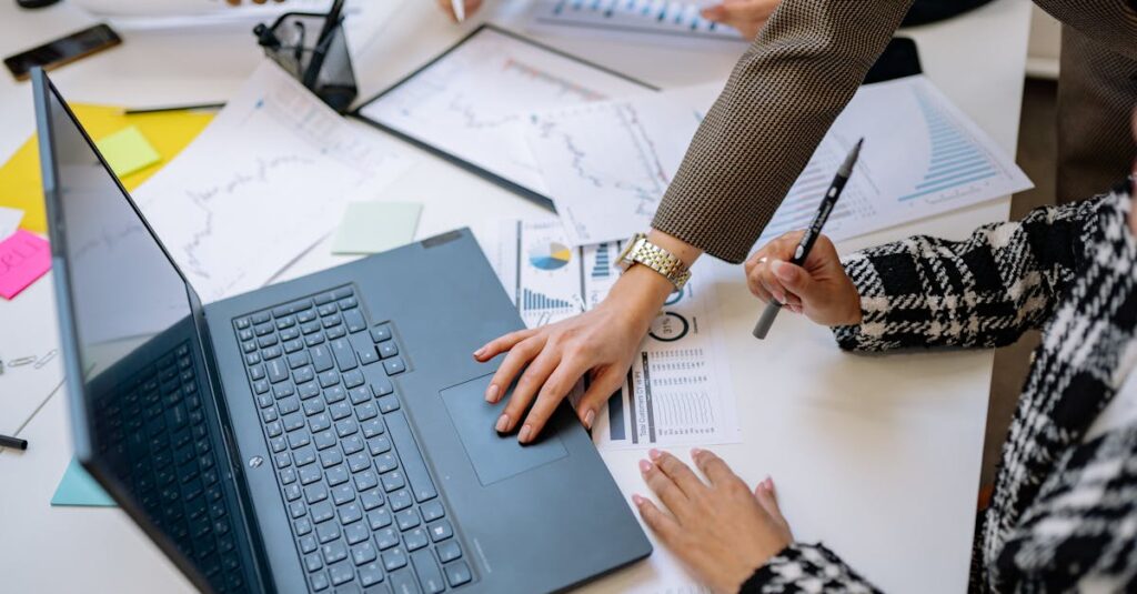 Business team analyzing data and charts during a meeting with a laptop on the table.