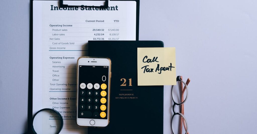 Top view of a desk with income statement, phone calculator, and tax reminder note.