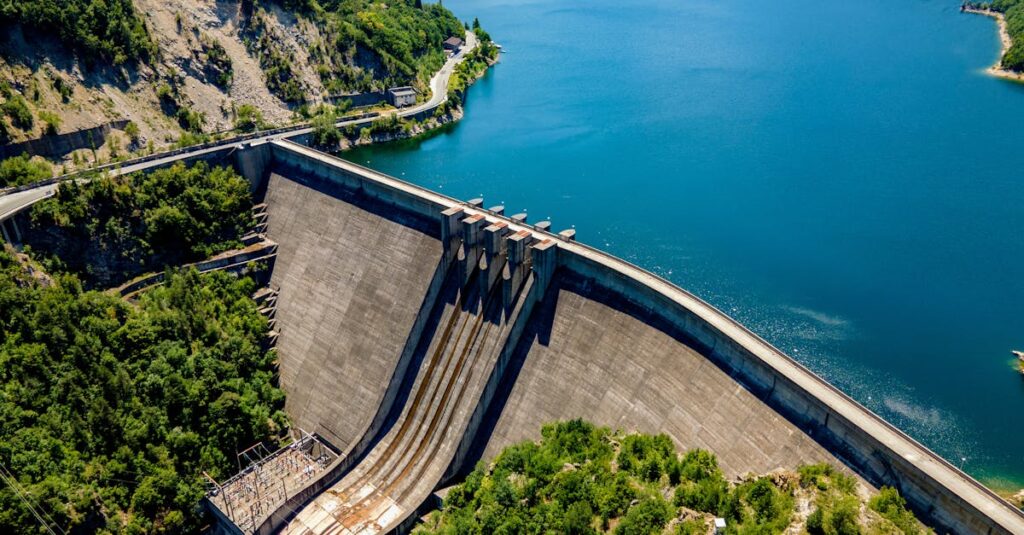 A stunning aerial view of Vacha Dam surrounded by lush greenery and blue waters in Bulgaria.