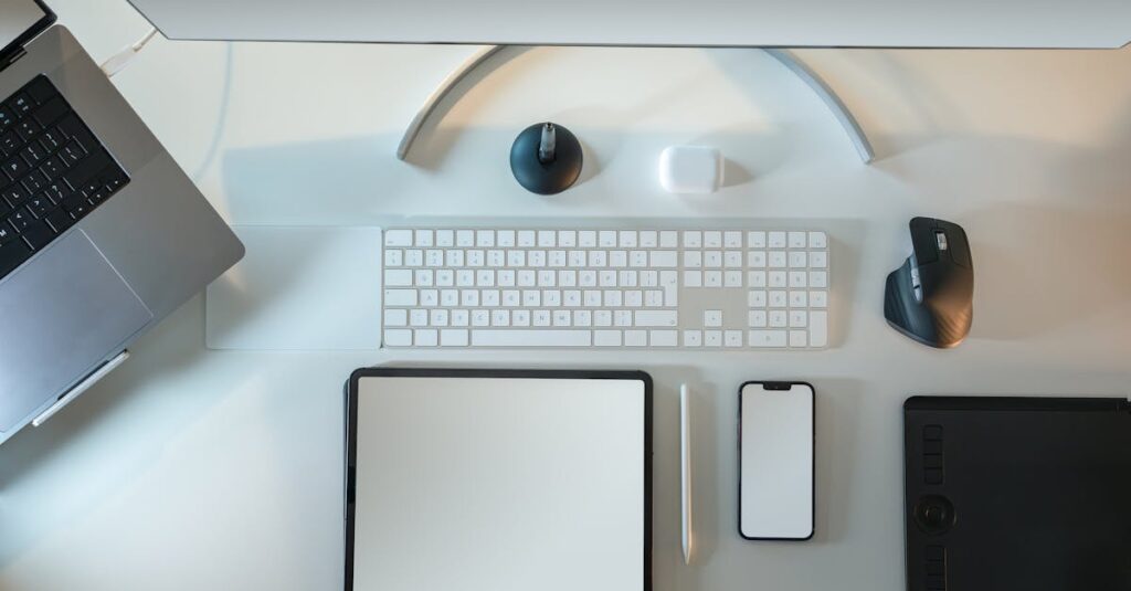 Top view of modern tech workspace featuring laptop, tablet, smartphone, and accessories.