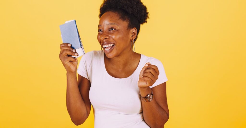 Smiling woman holding passport ready for a vacation against a yellow background.