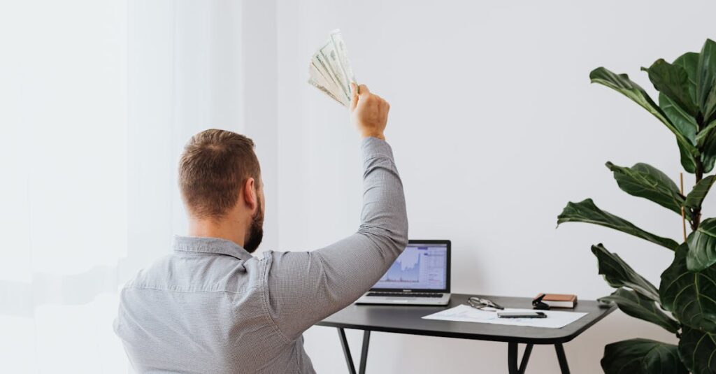A man in a home office raises cash, symbolizing financial success and achievement.
