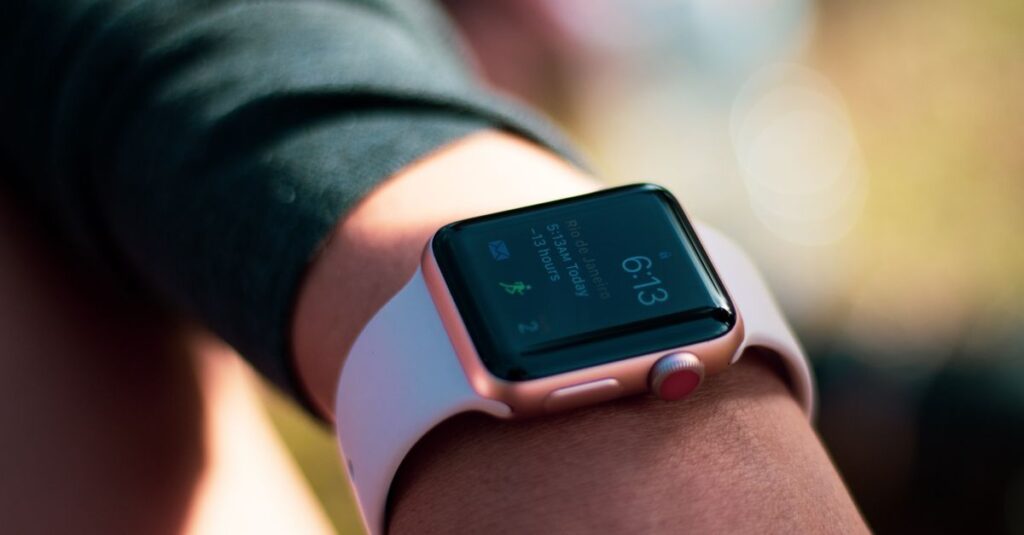 Smartwatch with digital screen displaying 6:13, worn on wrist outdoors.