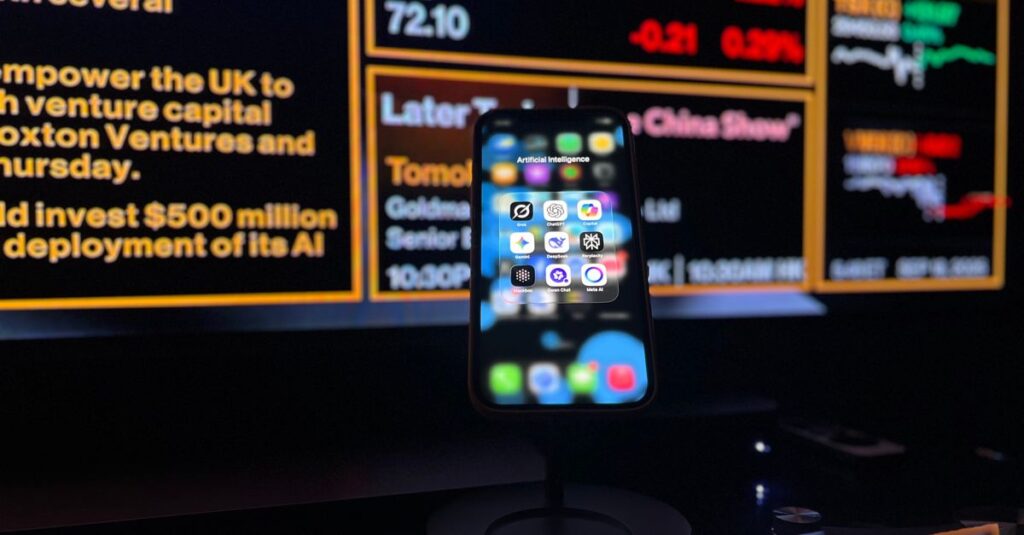 Smartphone displaying AI apps in front of a financial data screen in London.