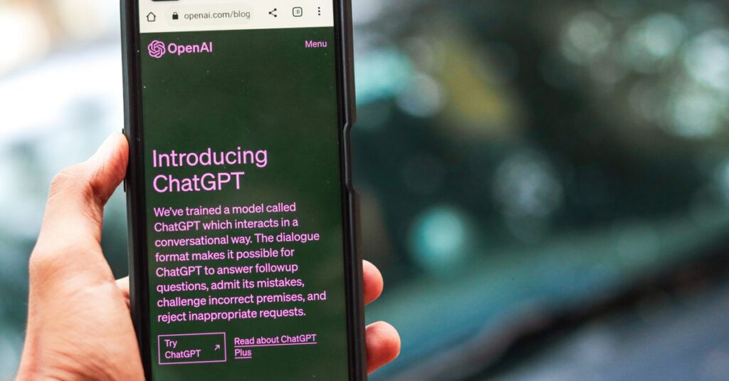 Close-up of a smartphone showing ChatGPT details on the OpenAI website, held by a person.